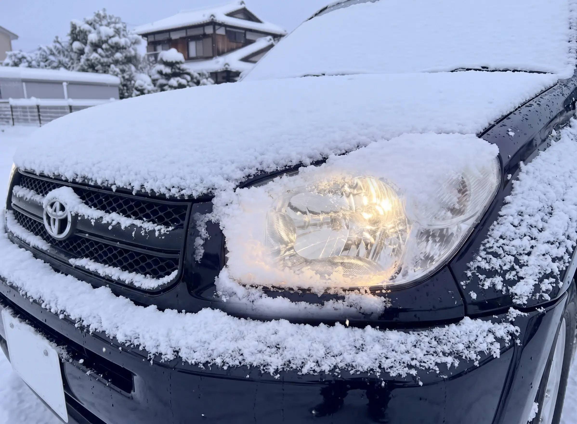 雪の積もった車のライトを電球色に変えた画像